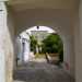 Attraverso un arco tufaceo bianco accediamo al cortile